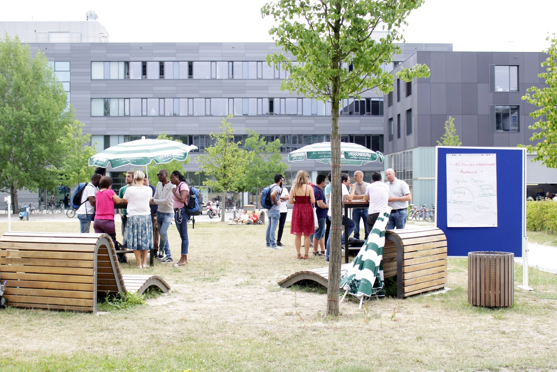 Menschen auf der Campus Wiese im Gespräch