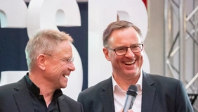 Two men laughing and talking.