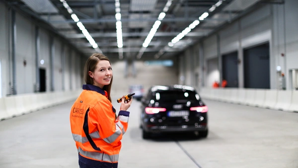 Junge Frau steht in einer Halle für Fahrzeugtests