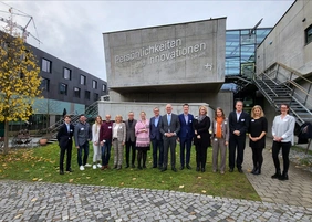 Gruppenfoto Frauen und Männer im Freien vor der Hochschule